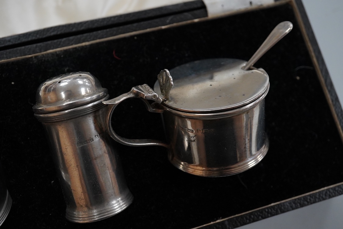 A George V silver tall cream jug, Birmingham, 1930, 17.2cm, a 1950's silver small mug, London, 1955 and a cased 1930's silver three piece condiment set.